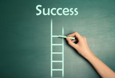 Woman drawing ladder on green chalkboard, closeup. Steps to success