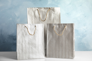 Silver shopping paper bags on white table