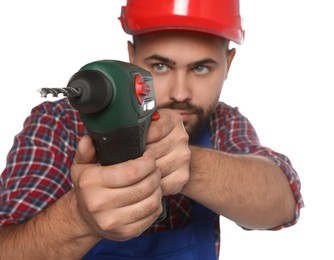 Young worker in uniform with power drill against white background, focus on tool