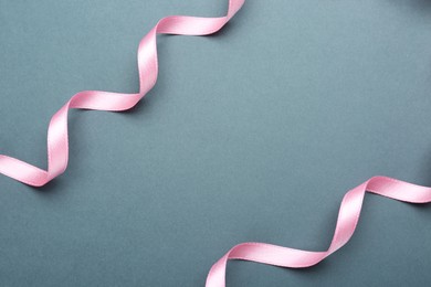 Photo of Beautiful pink ribbons on grey background, flat lay. Space for text