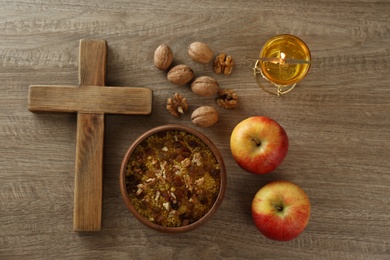 Photo of Cross and fasting meals on wooden table, flat lay. Lent season