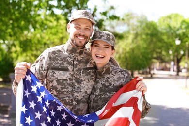 Military couple with American flag in park