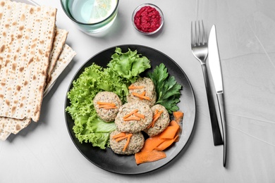 Flat lay composition with plate of traditional Passover (Pesach) gefilte fish  on light background