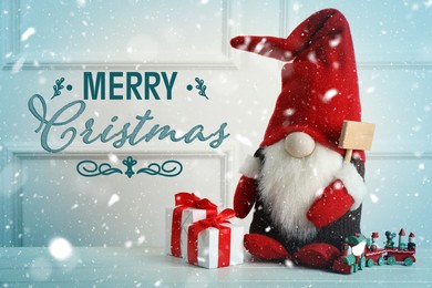 Merry Christmas! Cute gnome, gift boxes and toy train on white wooden table 