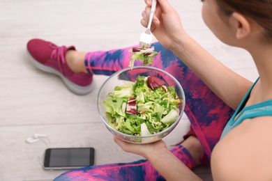 Young woman in fitness clothes having healthy breakfast at home, closeup