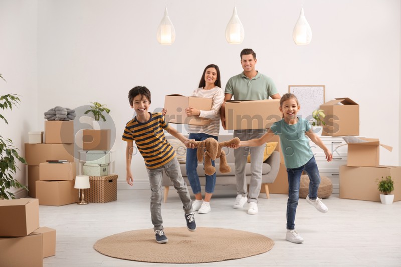 Happy family in room with cardboard boxes on moving day