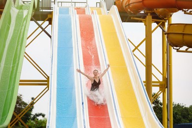 Photo of Young woman on slide in water park