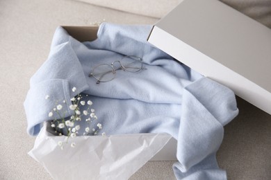Soft cashmere sweater in box on sofa