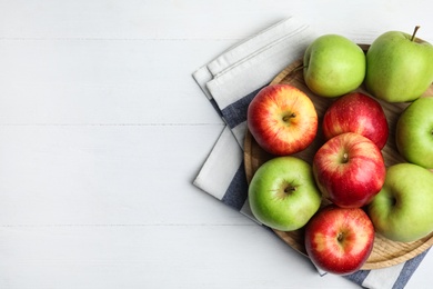 Photo of Different sweet apples on white wooden table, top view. Space for text