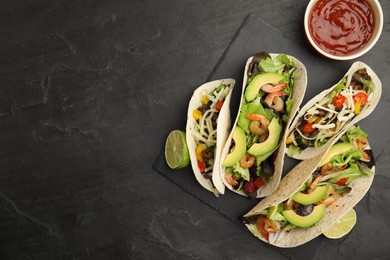 Delicious tacos, lime and sauce on black table, flat lay. Space for text