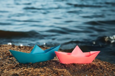 Two paper boats near river on sunny day