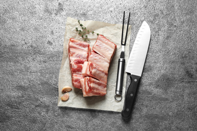 Photo of Raw ribs with thyme on grey table, flat lay