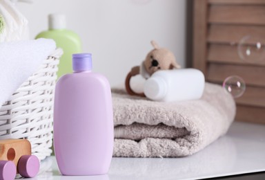 Photo of Baby cosmetic products, toys and towel on white table