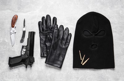Photo of Flat lay composition with balaclava and weapons on light table