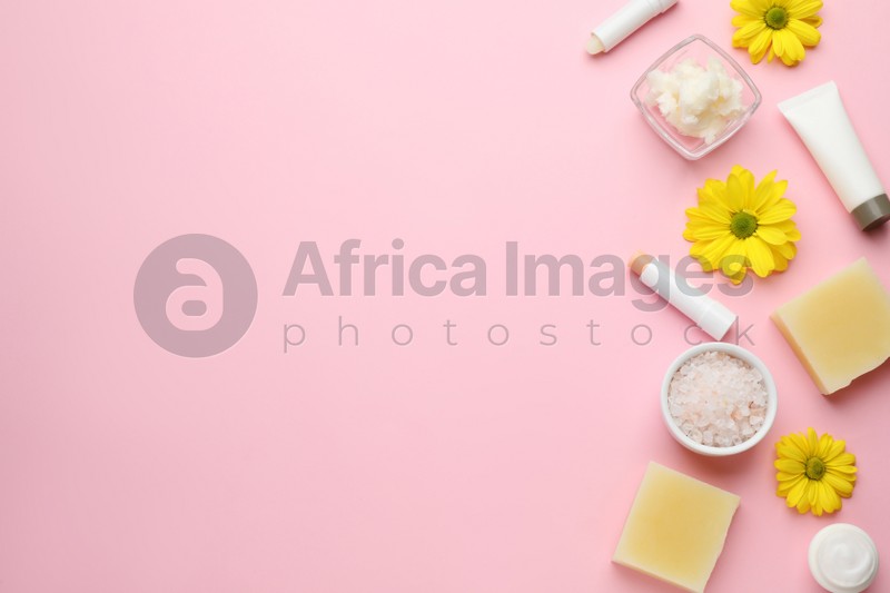 Flat lay composition with beeswax and cosmetic products on pink background. Space for text