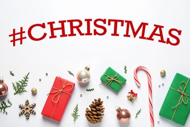 Hashtag Christmas, gift boxes and festive decor on white background, flat lay