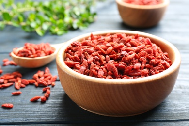 Bowl of dried goji berries on wooden table, closeup. Healthy superfood