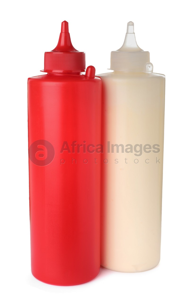 Plastic bottles of tasty mayonnaise and ketchup on white background