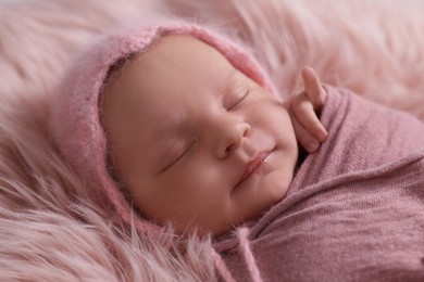 Adorable newborn baby lying on faux fur, closeup