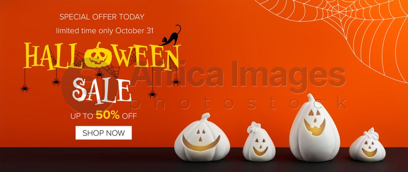 Image of Halloween sale banner with white pumpkin shaped candle holders on bright orange background 