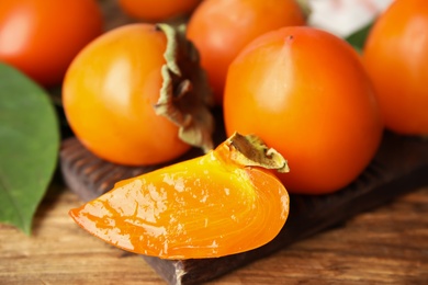 Delicious fresh persimmons on wooden table, closeup