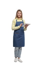 Beautiful young woman in denim apron with tablet on white background