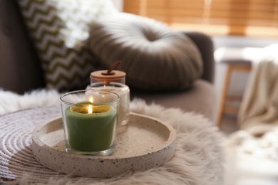 Aroma candles on grey sofa indoors. Interior design