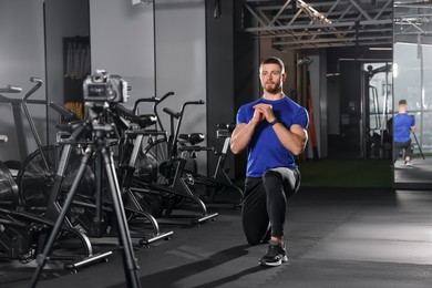 Photo of Man recording workout on camera at gym. Online fitness trainer