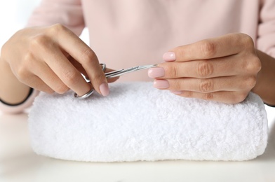 Woman cutting nails at table, closeup. At-home manicure
