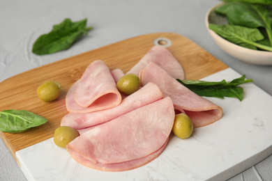 Ham with olives and spinach on table