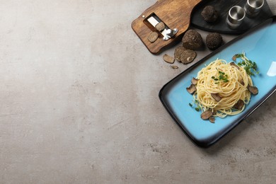 Delicious pasta with truffle slices and microgreens served on light grey table, flat lay. Space for text