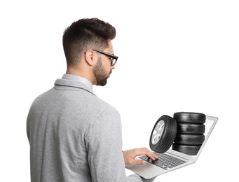 Image of Man buying car tires from online auto store via laptop on white background. Delivery service