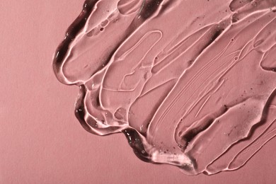 Transparent cosmetic gel on pink background, top view