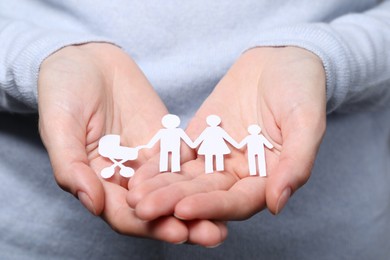 Photo of Woman holding paper family figures, closeup. Insurance concept