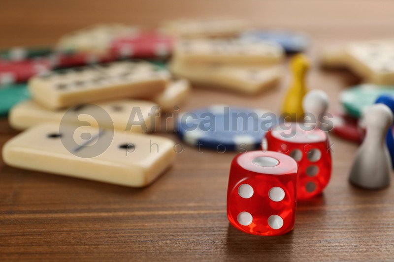 Elements of different board games on wooden table, closeup
