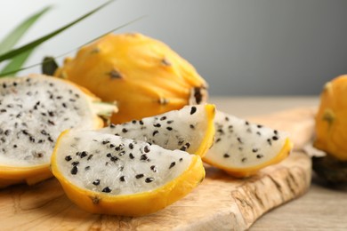 Delicious cut dragon fruit (pitahaya) on wooden board, closeup. Space for text