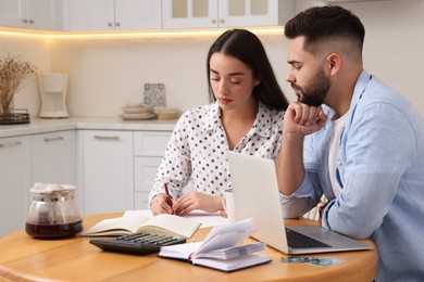 Young couple discussing family budget in kitchen