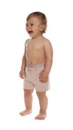 Photo of Cute baby in shorts learning to walk on white background