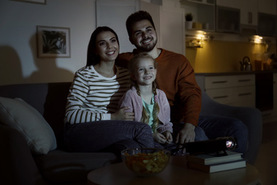Family watching movie using video projector at home