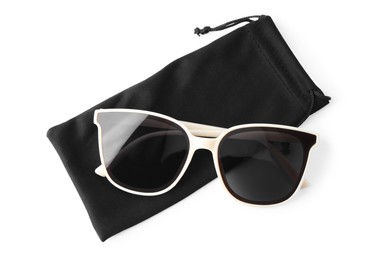 Photo of Stylish sunglasses with black cloth bag on white background, top view
