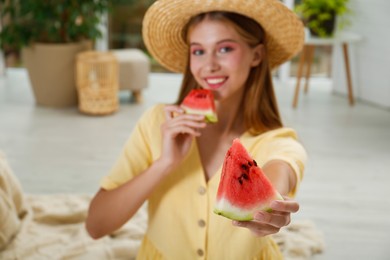 Beautiful teenage girl with slices of watermelon at home, focus on hand