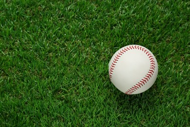 Photo of Baseball ball on green grass, top view with space for text. Sports game