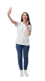 Photo of Smiling young woman taking selfie with smartphone and showing peace sign on white background