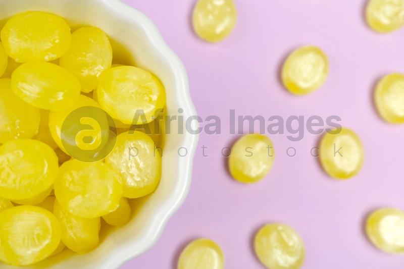 Flat lay composition with tasty lemon drops on violet background