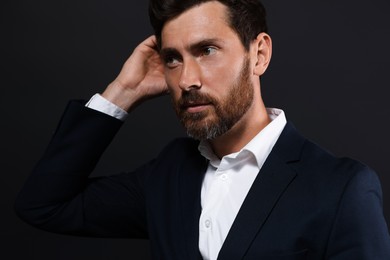 Photo of Portrait of handsome bearded man looking away on black background
