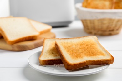 Slices of tasty toasted bread on white wooden table, closeup