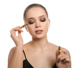 Beautiful woman applying eyeliner on white background. Stylish makeup