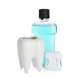 Tooth shaped holder, dental floss and mouthwash on white background