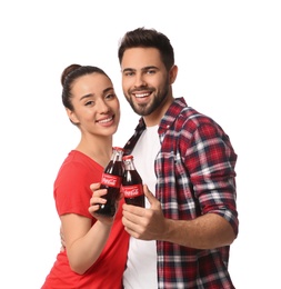 MYKOLAIV, UKRAINE - JANUARY 27, 2021: Young couple holding bottles of Coca-Cola on white background