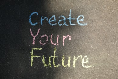 Photo of Phrase Create Your Future written on asphalt, top view